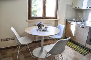 Bilocale in campagna - Assisi في أسيسي: مطبخ مع طاولة وكراسي في مطبخ