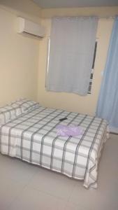 Bett in einem Zimmer mit Fenster in der Unterkunft Pousada Alto de Junqueira in Mangaratiba