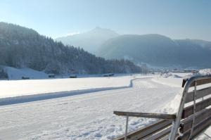 a snow covered field with a fence next to a river at Appartements Christine in Bezau +63 photos