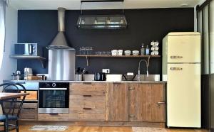 a kitchen with wooden cabinets and a refrigerator at Guest house " Gîte L'ATELIER DU 6"- calme - jardin in Tours