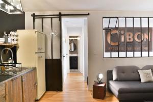 a living room with a couch and a refrigerator at Guest house " Gîte L'ATELIER DU 6"- calme - jardin in Tours