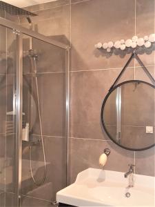 y baño con ducha, lavabo y espejo. en Guest house " Gîte L'ATELIER DU 6"- calme - jardin en Tours