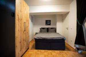 ein kleines Schlafzimmer mit einem Bett und einem Holzboden in der Unterkunft Apartment Ilaria in Tuttlingen