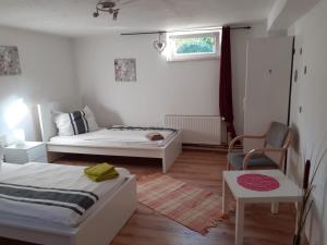 1 dormitorio con 2 camas, silla y ventana en Souterrain Apartment Laatzen, en Hannover