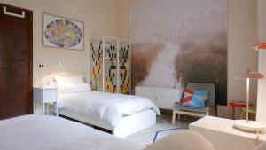 a bedroom with two beds and a painting on the wall at Three Rooms in Messina