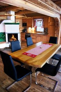 a wooden table in a kitchen with a fireplace at Alpenchalets Weissenbacher in Tamsweg
