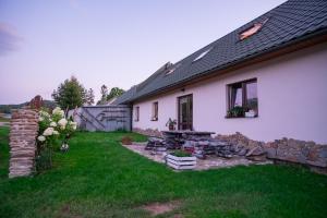 ein Haus mit einer Feuerstelle im Hof in der Unterkunft Kwatery u Anety in Ustrzyki Górne