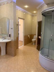 a bathroom with a shower and a sink and a toilet at Hotel Versal in Krasnodar