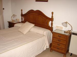 a bedroom with a bed and a nightstand with two lamps at Casa Gazquez in Santo Tomé