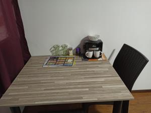 a wooden table with two chairs and a coffee maker at Habitaciones Alkimya in Loja