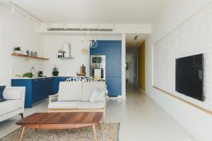 uma sala de estar com um sofá branco e uma mesa em AirTLV - Rambam Residence W Private MAMAD! em Tel Aviv
