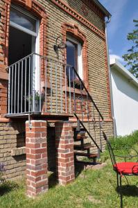 ein Backsteinhaus mit einem Balkon und einem roten Stuhl in der Unterkunft Maison Elise & Philipp in Wiesbaden