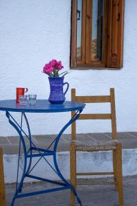 una mesa azul con un jarrón de flores y una silla en Koilon Apartments, en Mókhlos