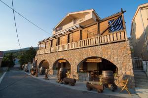 a stone building with an archway in a street at Apartments Ribarica in Karlobag