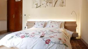 メッシーナにあるThree Roomsのベッドルーム1室(花が咲く白いベッド1台付)