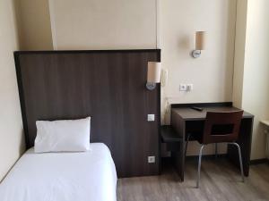 ルヴァロワ・ペレにあるホテル ドンジュのベッドルーム1室(ベッド1台、デスク、ベッド1台、椅子付)