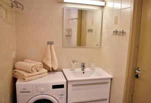 ein Badezimmer mit einer Waschmaschine und einem Waschbecken in der Unterkunft Kuressaare Holiday Apartments in Kuressaare