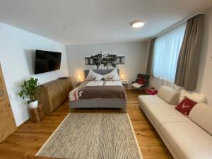 sypialnia z łóżkiem i kanapą w obiekcie Alpenperle w mieście Obsteig