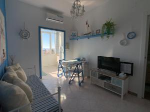 a living room with a tv and a table at Very cosy house with fabulous sea view! in Pietra Ligure