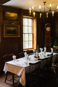 comedor con mesas y sillas y reloj en The Outing lodge, en Stillwater