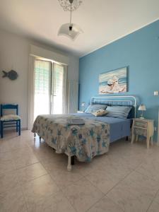 a bedroom with a bed and a blue wall at Very cosy house with fabulous sea view! in Pietra Ligure