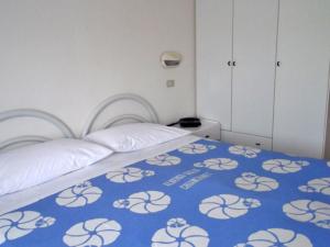 a bedroom with a bed with a blue and white blanket at Albergo Giglio in Chianciano Terme