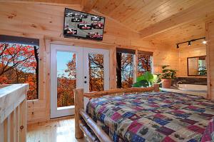 sypialnia z dużym łóżkiem w drewnianym domku w obiekcie #820 Honeymoon Hideaway w mieście Gatlinburg