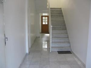 a hallway with stairs in a house with a door at Gite Mella in La Courneuve