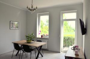 a dining room with a table and chairs and a window at Maison Elise & Philipp in Wiesbaden