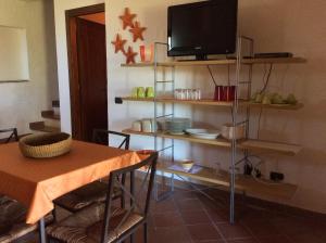 a dining room with a table and a television on a shelf at Villa Bea in Chia