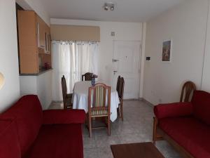 a living room with a table and a red couch at Departamentos Devoto in Buenos Aires