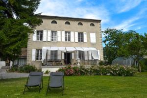 two chairs sitting in the grass in front of a building at Villa Rhôna in Andancette