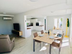 a dining room and living room with a table and chairs at Casa Solaris at Anfi Beach with Private Terrace, Pool & Netflix in Arguineguín