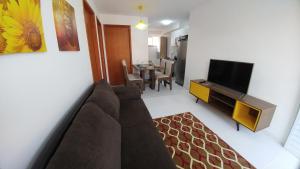 ein Wohnzimmer mit einem Sofa und einem Flachbild-TV in der Unterkunft Condomínio Residencial Tranquilidade na Beira do Rio in Paulo Afonso