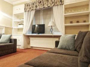 a living room with a couch and a television at American House Hennela in Warsaw