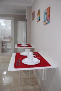 Biały stół z dwoma talerzami i kubkami w obiekcie Nice and New Studio very close to the city center 2ºA w Maladze