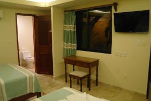 a bedroom with a desk and a bed and a mirror at Hotel Real Del Mayab in Playa del Carmen