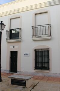 een wit gebouw met 2 balkons en een zwarte deur bij Casa Rialto in Olivenza