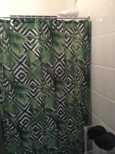 a shower curtain with a green and white pattern at Casanapraia Bertioga in Bertioga +54 photos
