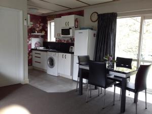 a kitchen with a table and chairs and a dining room at Down South Cottage in Invercargill