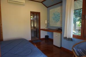 a bedroom with a bed and a window and a table at Blue Sky Resort Pai in Pai