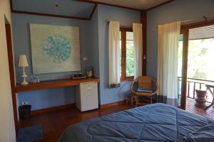 a bedroom with a bed and a desk and windows at Blue Sky Resort Pai in Pai
