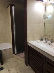 een badkamer met een wastafel en een douche met een spiegel bij Casa Rialto in Olivenza