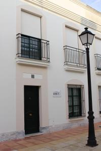 um edifício branco com uma porta preta e uma luz de rua em Casa Rialto em Olivenza