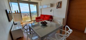 comedor con mesa y sillas y sofá rojo en Mirador al mar, en Bellreguart