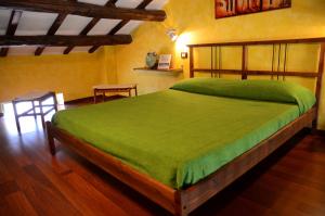 a bedroom with a large bed with a green bedspread at Le Suite Bracciano in Bracciano