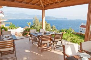a patio with a table and chairs and a view of the ocean at Lycia Hotel in Kaş