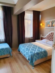 a bedroom with two beds and two windows at Şehir Hotel Old City in Istanbul