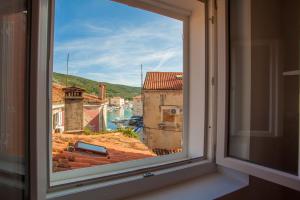 a window with a view of a harbor at Apartments Calma in Cres