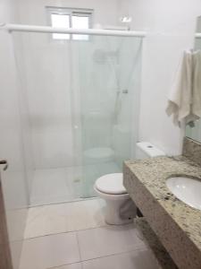 ein Bad mit einer Dusche, einem WC und einem Waschbecken in der Unterkunft Yolanda Family House in Foz do Iguaçu